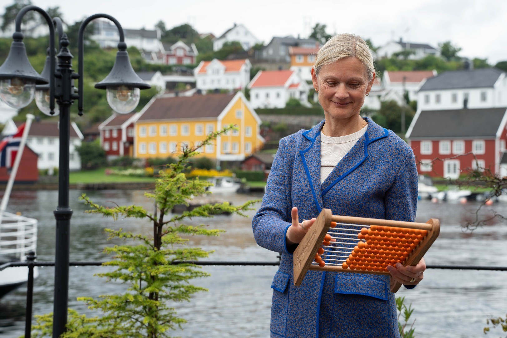 Hanne Løvstad bruker en kuleramme til å telle hvor mange selskaper som kutter utslipp i tråd med Parisavtalen